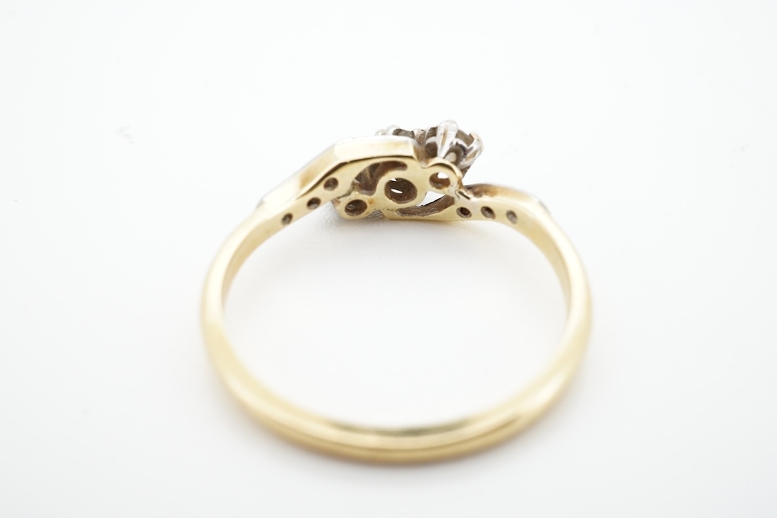 A three-stone diamond ring, early 20th century, centring on a diagonal line of three circular-cut diamonds totalling approximately 0.24 carats, to asymmetrical shoulders set with smaller rose-cut diamonds, mounted in gol